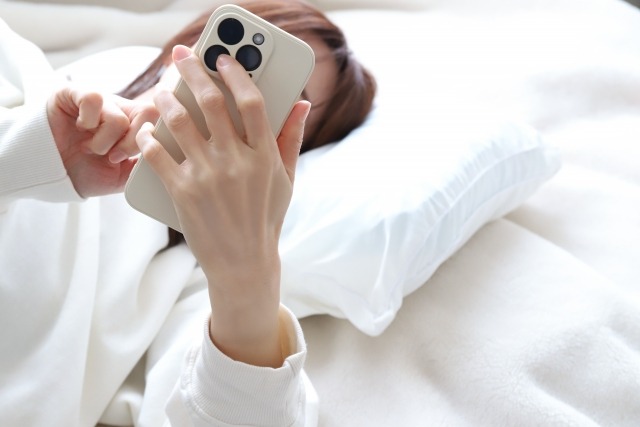 子宮筋腫や子宮全摘についてスマホで検索する女性
